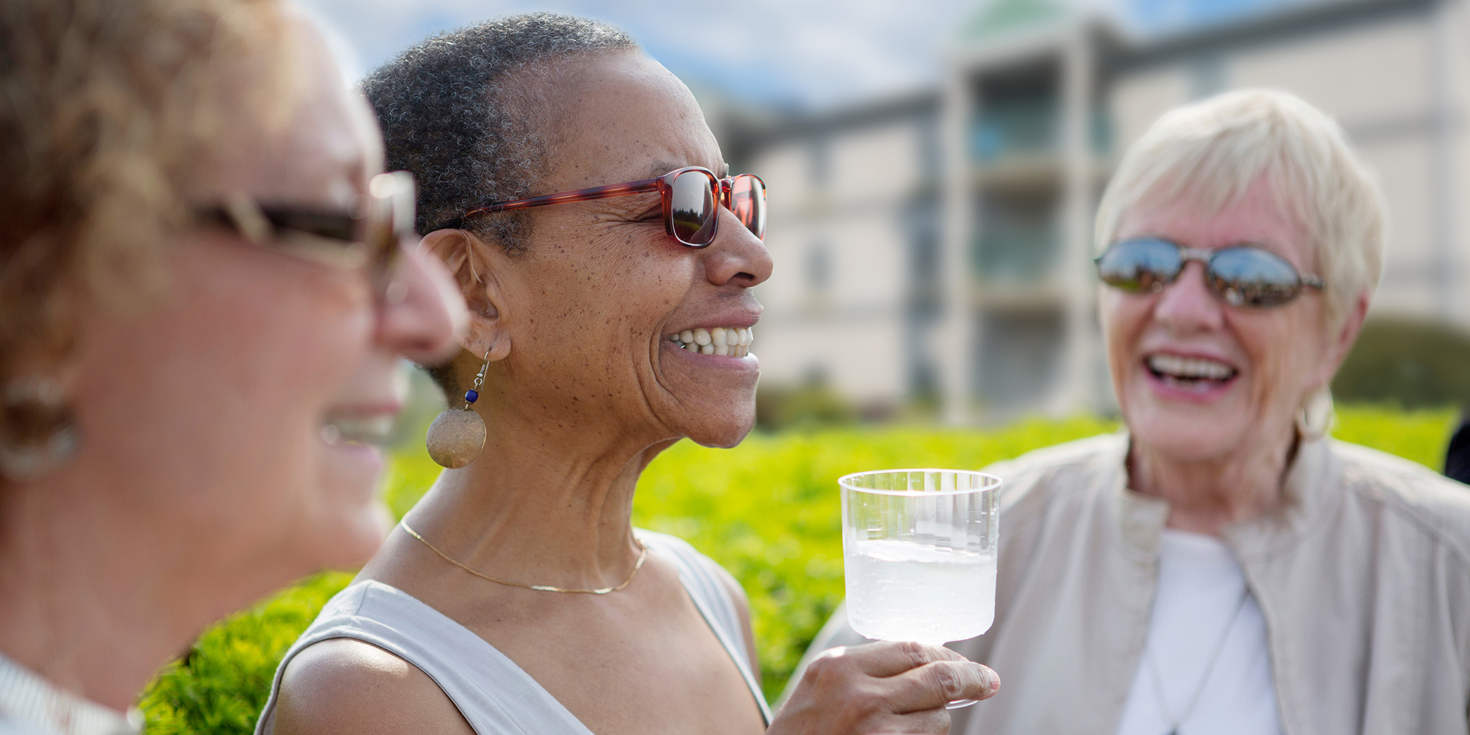 Three senior women gathering outdoors at a continuing care retirement community