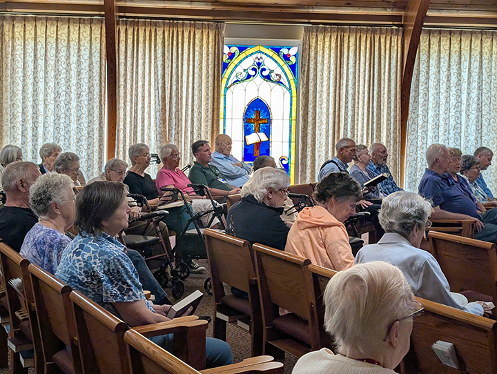 senior living residents and staff singing in the chapel