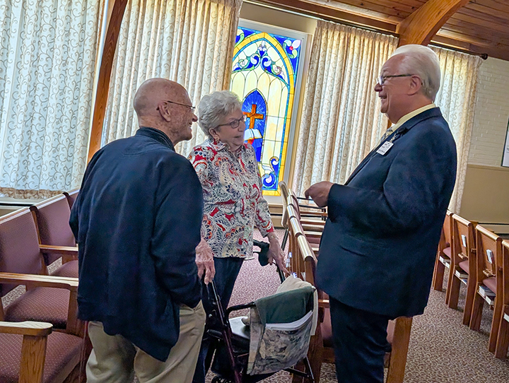 Residents and board member talk in chapel