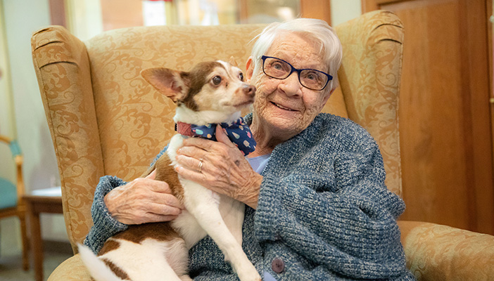 woman holding dog in chair